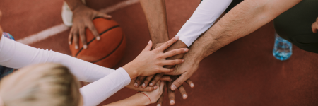 a basketball team with all hands in a circle