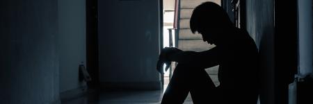 a person in a dark hallway with their head down