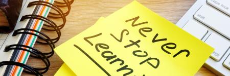 a sticky note with a note written that says, "never stop learning"
