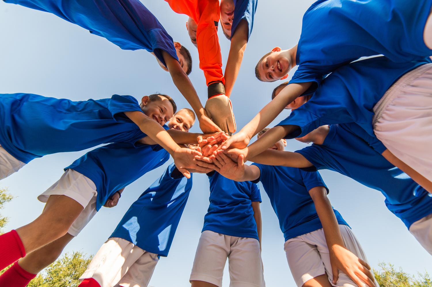 "a group of kids huddled in a circle"